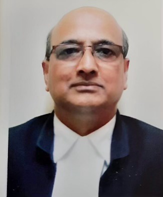 Headshot of a smiling man with short hair wearing a collared shirt